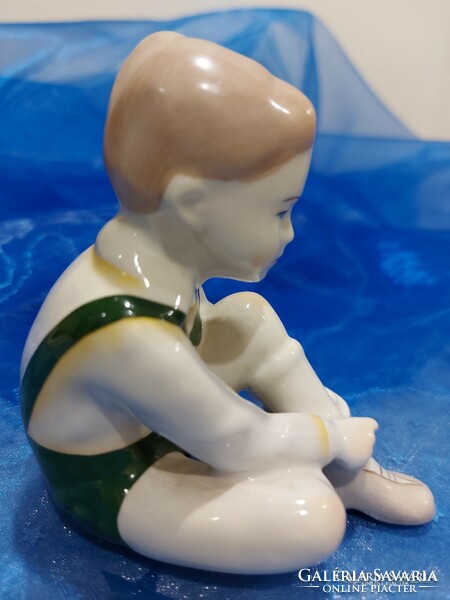 Aquincumi porcelán figura,cipőt húzó fiú.