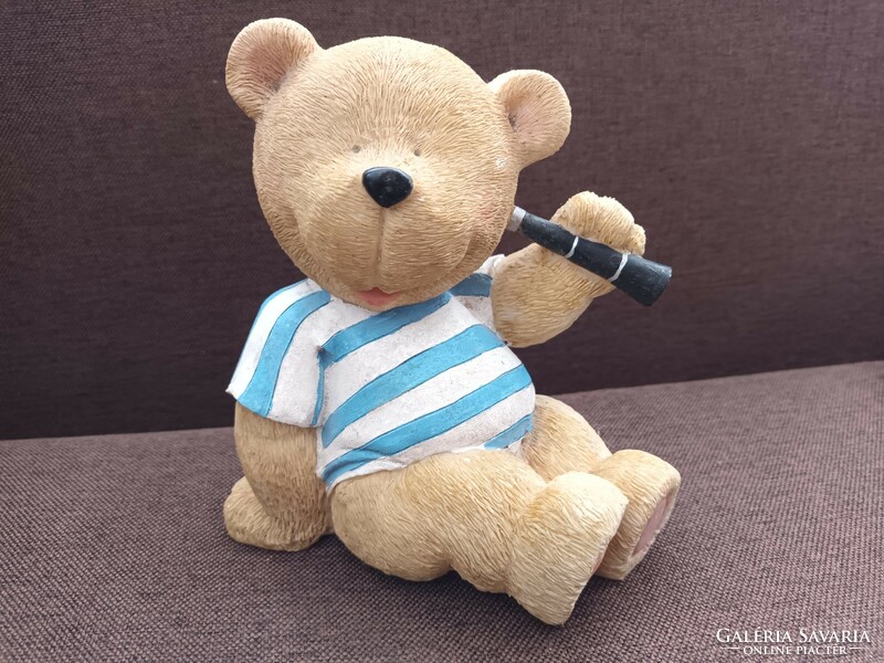 Large old, retro teddy bear in a striped t-shirt with binoculars