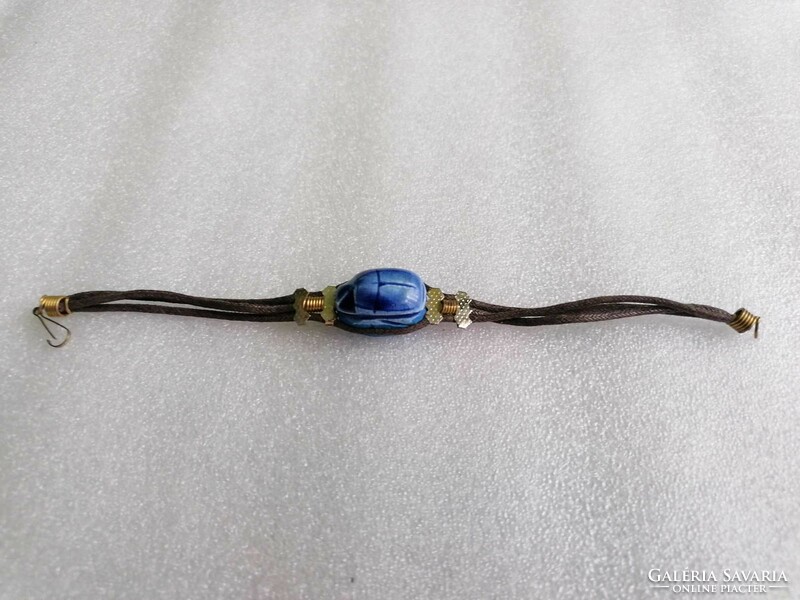 Blue scarab beetle on a leather bracelet