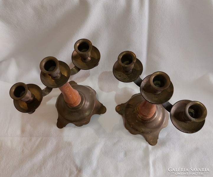 2 identical three-pronged candle holders with wooden bodies