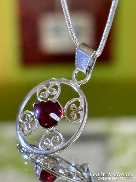 A beautiful silver necklace and pendant, embellished with a garnet stone