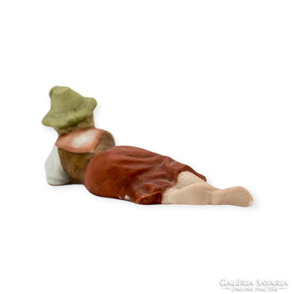 Alpine girl in a hat lying on a biscuit