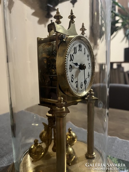 Antique, 400-day rotating pendulum mechanical clock under a glass cover