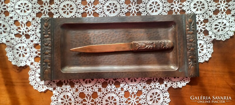 A copper/bronze leaf-cutting knife marked by an artisan on a tray