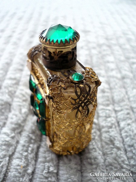 Small perfume bottle with an old openwork pattern filled with stones