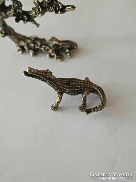 Copper mini sculptures of birds on tree branches and crocodiles