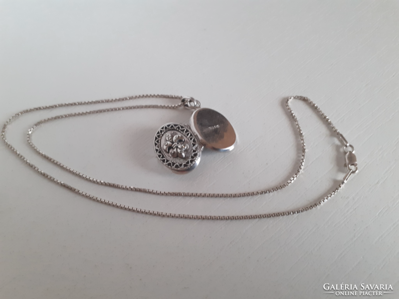 A marked silver necklace in good condition with a marked chiselled silver openable heart pendant