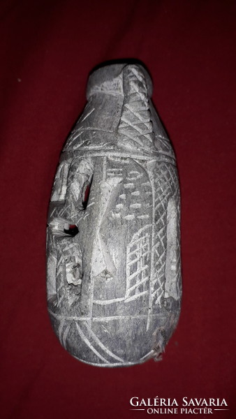 A small pot carved from antique sandstone with a figure and hieroglyphs is an Egyptian ornament according to the pictures