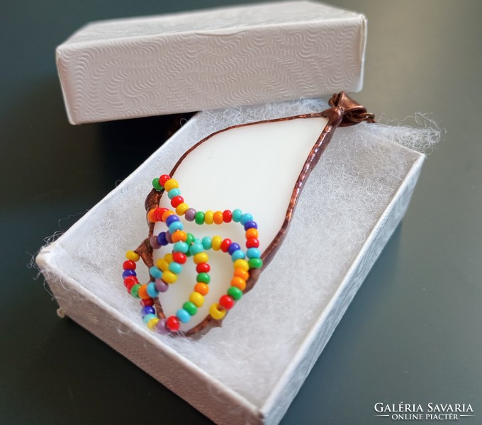 Handmade glass jewelry, waves of colored pearls on white glass