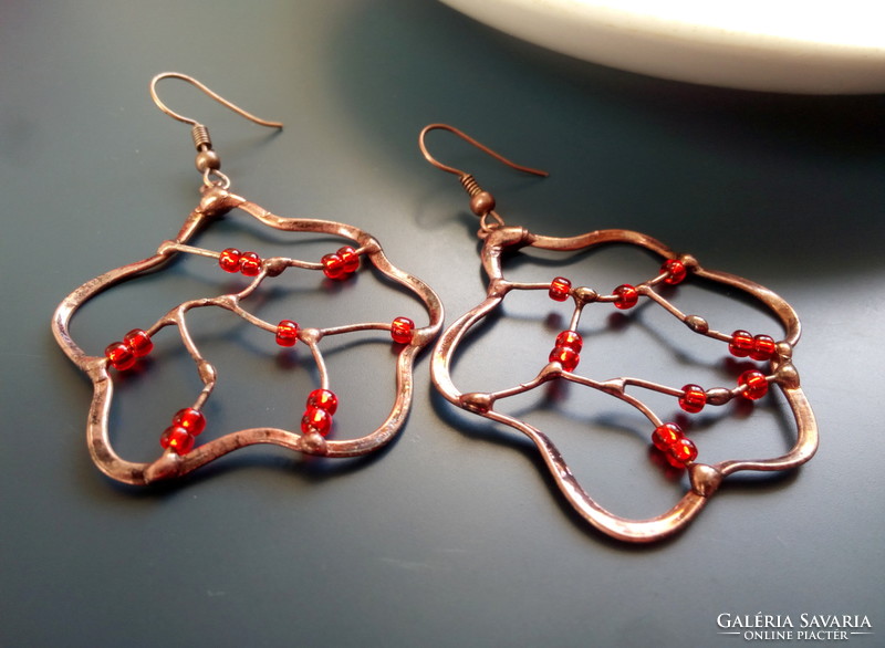 Swirling red pearl earrings soldered into a copper wire frame