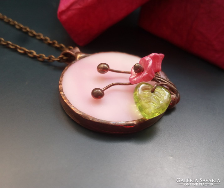 Handcrafted glass jewelry with a bouquet of flowers on pink glass