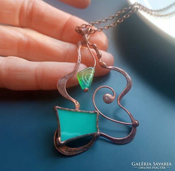 A sophisticated handcrafted product, glass jewelry pendant with turquoise glass and pearls