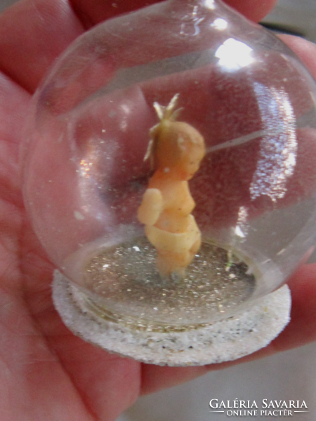 A small wax Jesus Christmas tree ornament in a sphere