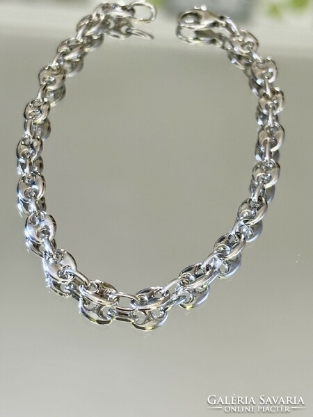 A sleek, shiny, solid silver bracelet