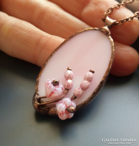 Handcrafted glass jewelry with a bouquet of flowers on pink glass