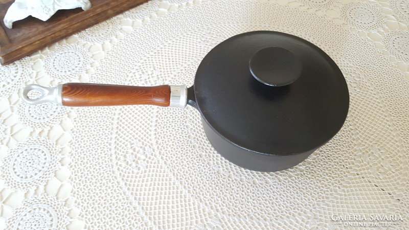 Cast iron pot with wooden legs and lid