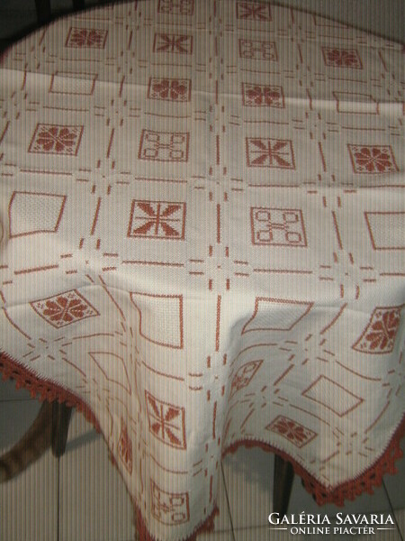 A beautiful hand-embroidered woven tablecloth with a cross-stitch crocheted edge