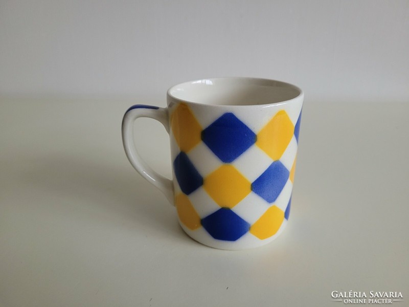Old granite mug with a blue and yellow checkered pattern