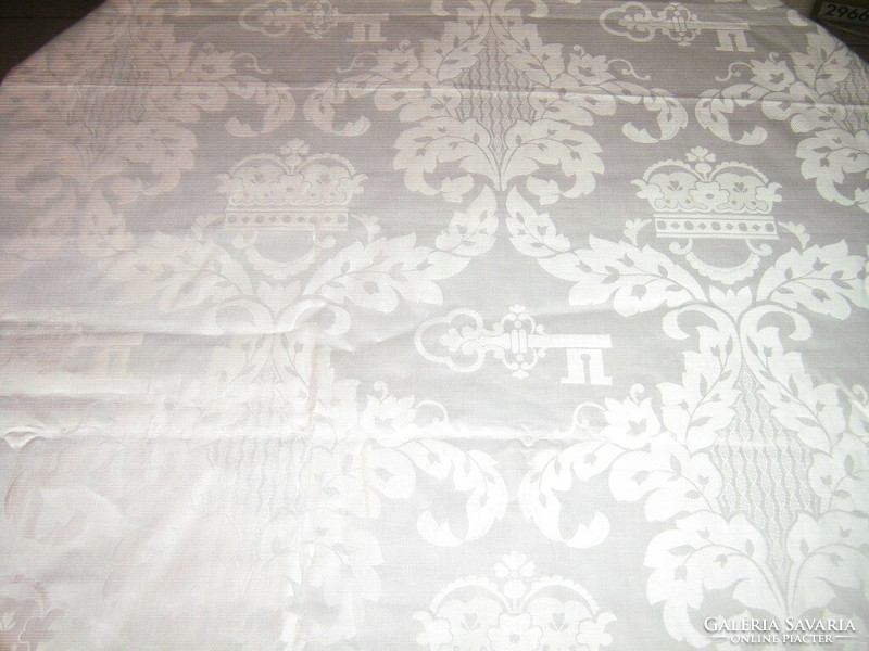 Beautiful shiny baroque pattern on elegant shiny snow-white silk tablecloth