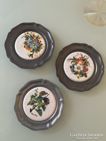 Three metal plates with floral inlays.