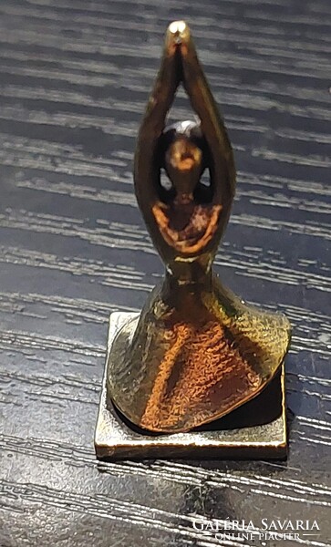 Bronze figure of a woman doing yoga in a skirt